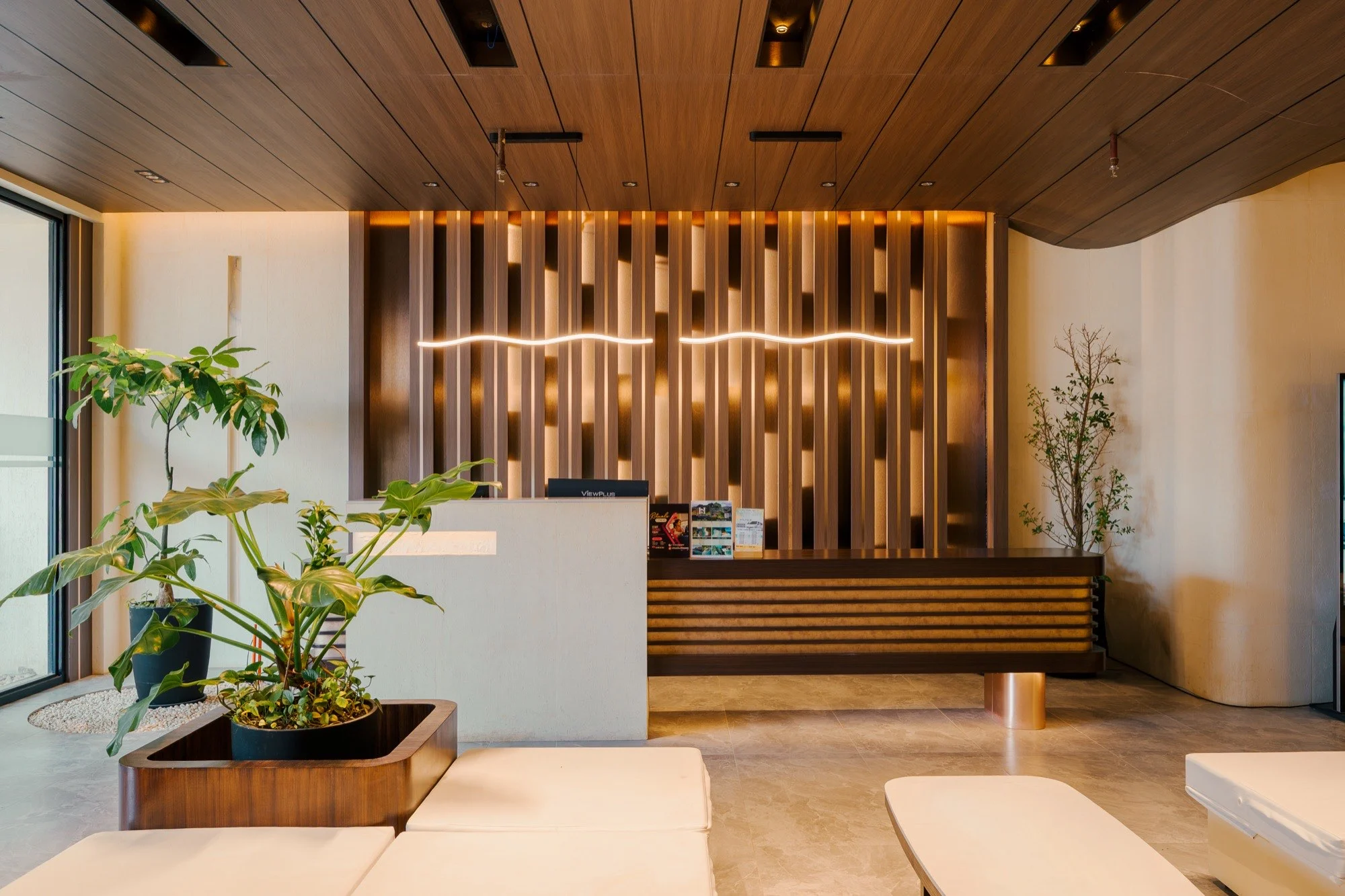 S Resort lobby with wood finishes, plants and lounge seating